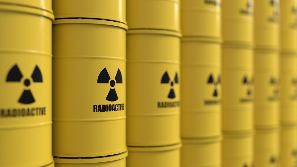 Abgebildet sind gelbe Metallfässer, in denen radioaktive Substanzen gelagert werden. Auf den Fässern steht mit schwarzer Schrift "radioacitve" (zu Deutsch: radioaktiv). 